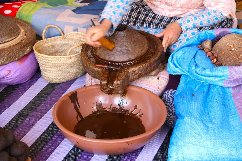 Grinding roasted argan kernels on a traditional stone mill