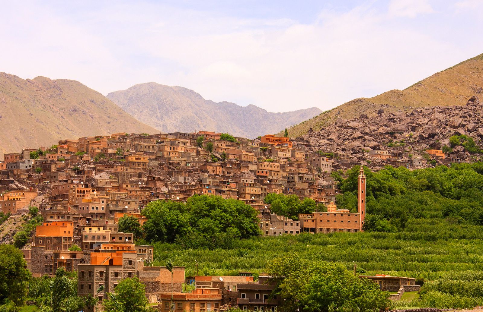 Hillside village with a minaret surrounded by green terraces