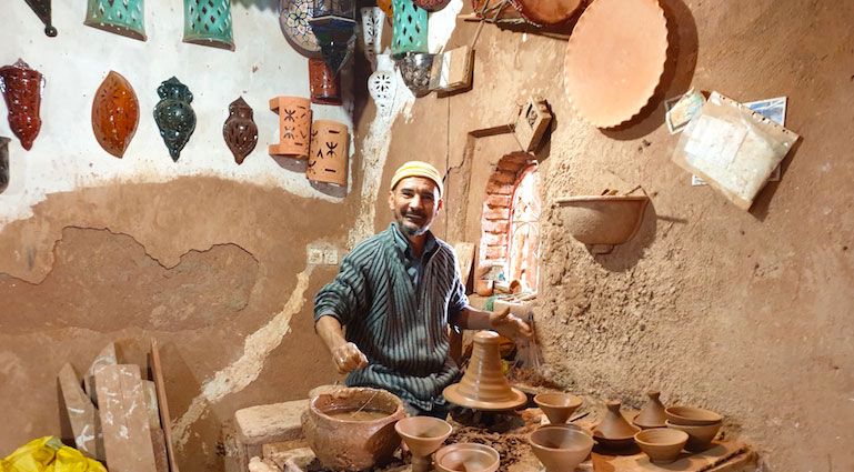 Potter shaping clay on his wheel in an Ourika workshop