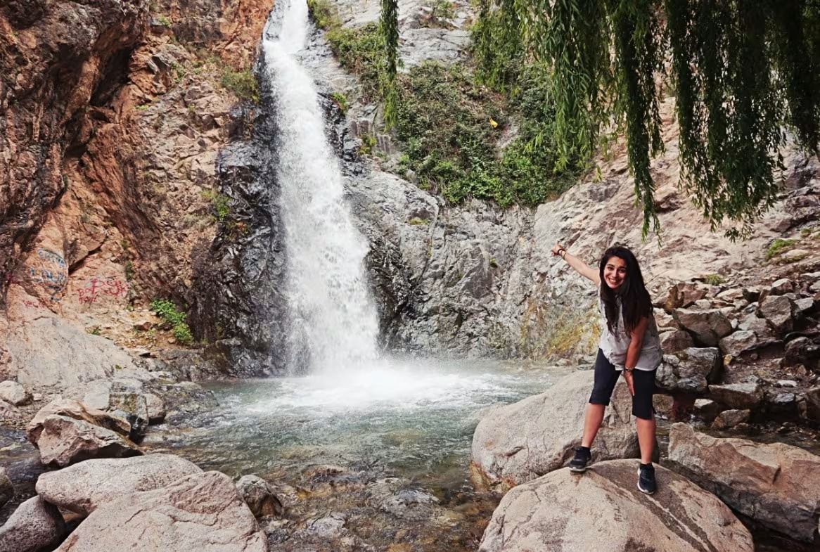 Visiteuse debout sur les rochers devant une cascade de Setti Fatma